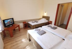 A bed or beds in a room at Kamilla Panzió és Rendezvényház