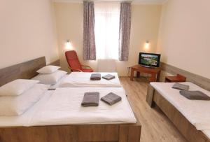 A bed or beds in a room at Kamilla Panzió és Rendezvényház