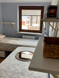 a room with two beds and a mirror and a table at Apartament Przytulny w Krynicy-Zdrój in Krynica Zdrój