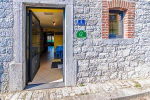 une porte menant à un bâtiment muni d'un panneau handicap. dans l'établissement Gite d'Hamptay, à Han-sur-Lesse