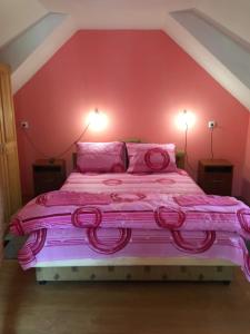 een roze bed in een kamer met 2 lampen bij Dupleks apartmani "Šumadija" Bogutovačka Banja in Bogutovac