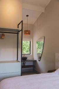 una camera con letto e specchio di Øko Villa a Juquei