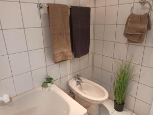 Un baño blanco con inodoro y lavabo. en Ferienwohnung Löwenzahn, en Bad Harzburg 19 fotos más