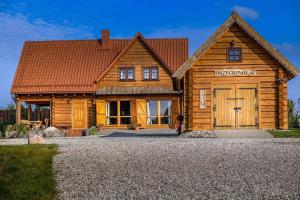 uma casa de madeira com uma grande porta em frente em Mazurska Arkadia em Stare Juchy