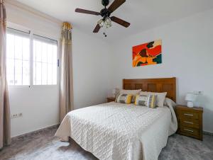 een slaapkamer met een bed en een plafondventilator bij Ruidera Playa in Los Alcázares