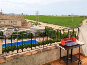 a grill on the balcony of a house with a pool at Ruidera Playa in Los Alcázares
