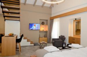 a hotel room with a bed and a tv on a wall at Roloi suites in Nafpaktos
