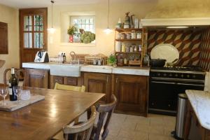 una cocina con una mesa de madera y una estufa en Beautiful house with swimming pool in the historic center, en Forcalquier