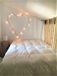 Dormitorio con cama en forma de corazón con luces en Grande suite sur jardin dans Montpellier centre, en Montpellier