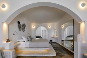 a bedroom with a bed and an archway at Suites of the Gods Cave Spa Hotel in Megalokhori