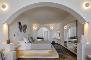 a bedroom with a bed and an archway at Suites of the Gods Cave Spa Hotel in Megalochori