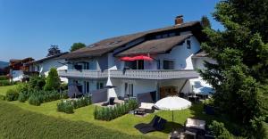 a large building with umbrellas on a lawn at Suit' & Frühstück Zum Latschen - Adults Only in Mauth