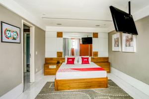 una camera da letto con un grande letto con cuscini rossi di OYO Nobs Hotel, São João de Meriti a São João de Meriti