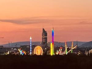 una città illuminata di notte con una ruota panoramica di Royal Swan Skyline, Wien a Vienna