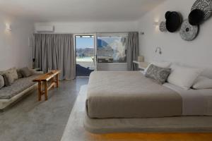 Un dormitorio con una cama grande y un sofá. en Suites of the Gods Cave Spa Hotel, en Megalokori 37 fotos más