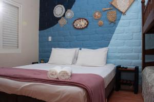 1 dormitorio con pared azul y 1 cama con toallas en Chácara Lápis Lazuli en Cavalcante