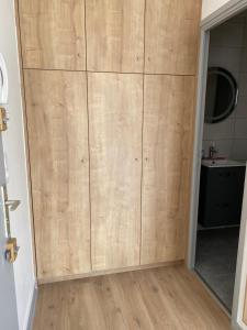 a large wooden wardrobe in a room with a bathroom at Appartement calme in Beaumont