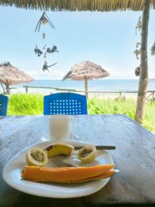 Juani beach bungalows في كيليندوني: صحن مع موز ونقانق على طاولة