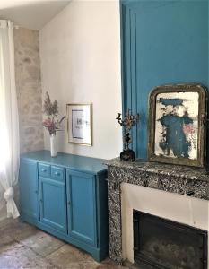 un armario azul junto a una chimenea en una habitación en Grande suite sur jardin dans Montpellier centre, en Montpellier