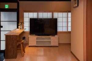una sala de estar con TV de pantalla plana en una cómoda en 京町屋の宿 天神庵, en Kioto