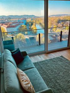 a couch in a living room with a large window at Royal Swan Skyline, Wien in Vienna