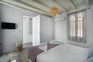 a white bedroom with a bed and a window at SERIFOS BELLA VISTA 2 in Livadion