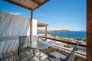 een balkon met een tafel en stoelen en de oceaan bij SERIFOS BELLA VISTA 2 in Livadion