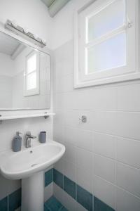 a white bathroom with a sink and a mirror at SERIFOS BELLA VISTA 2 in Livadion