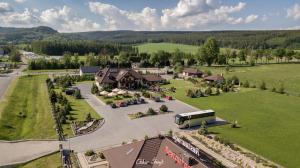 uma vista aérea de um resort com um autocarro estacionado num parque de estacionamento em Tajemniczy Ogród Szczytna em Szczytna