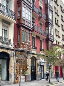 a tall red building with balconies on a city street at Bilbao Azkuna Home Centro EBI01832 in Bilbao