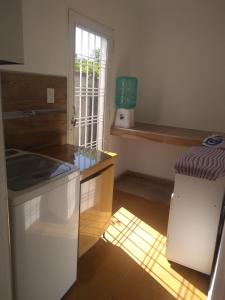 a kitchen with a sink and a refrigerator and a window at Casa Tranquila en pasaje , Villa Carlos Paz in Villa Carlos Paz