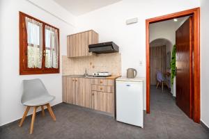 a kitchen with a white refrigerator and a chair at Marina's Studios in Perivolos