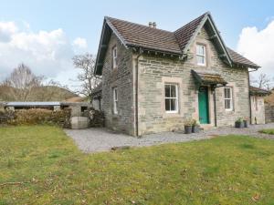 a stone house with a green door in a yard at The School House in Lochgilphead