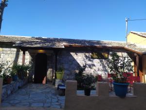 kamienny dom z patio z doniczkami w obiekcie Triple studio room in Mylopotamos Beach w mieście Tsagarada