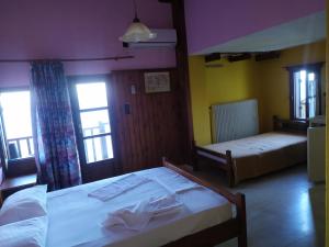 sypialnia z 2 łóżkami i 2 oknami w obiekcie Triple studio room in Mylopotamos Beach w mieście Tsagarada