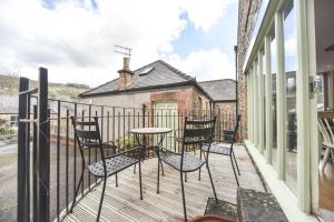 a patio with chairs and a table on a balcony at Coach House Mews in Matlock Bank