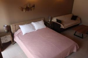 a bedroom with a large bed and a chair at Main square apartment in Symi