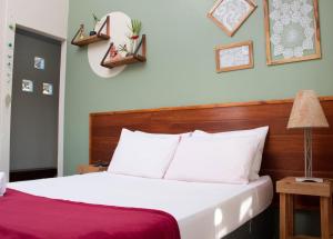 um quarto com uma cama com lençóis brancos e um cobertor vermelho em Chácara Lápis Lazuli em Cavalcante