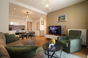un soggiorno con divano, sedie e TV di Apartments Royal - Belgrade Waterfront a Belgrado