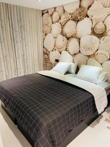 a bedroom with a bed with a wall of shells at Mil Palmeras - Bioko 208 - apartment for 6 in Pilar de la Horadada