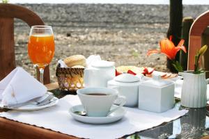 una mesa con una taza de café y un vaso de zumo de naranja en Magma Lodge, Pucon, en Pucón