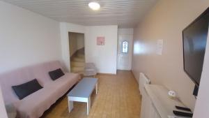 a living room with a couch and a tv at Gîte albertin in Albert