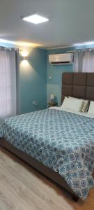 1 dormitorio con 1 cama grande y pared azul en Lovely Cozy Keito, en Palm-Eagle Beach