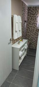 La salle de bains est pourvue d'un lavabo blanc et d'un miroir. dans l'établissement Lovely Cozy Keito, à Palm-Eagle Beach