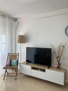 una sala de estar con TV de pantalla plana en un armario blanco en Apartament Roma V, Playa Gandia, en Gandía