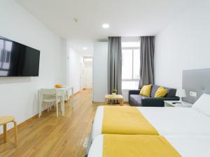 ein Hotelzimmer mit einem Bett und einem Wohnzimmer in der Unterkunft Ok Las Canteras Beach by CanariasGetaway in Guanarteme