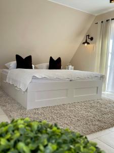 a white bed with two black cats sitting on it at Meine Ferienwohnung Pleissenhaus in Altenburg +21 photos
