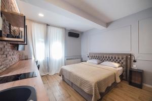1 dormitorio con cama y pared de ladrillo en Imperial Apartment P, 2nd Floor en Zagreb