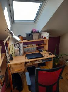 an attic office with a desk with a laptop on it at Chez Kiki in Épinal