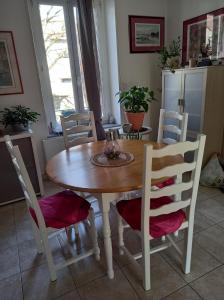 a dining room table with four chairs around it at Chez Kiki in Épinal